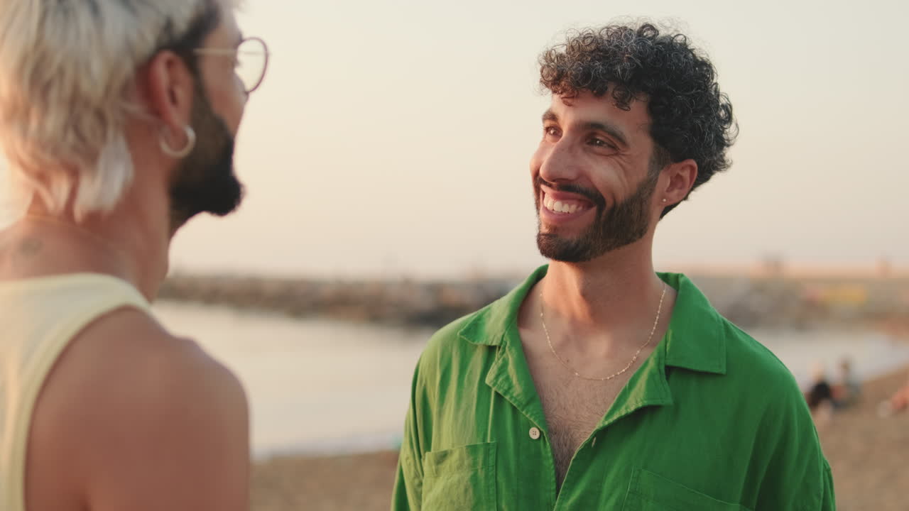 Uomo sorridente che conversa con un amico in spiaggia