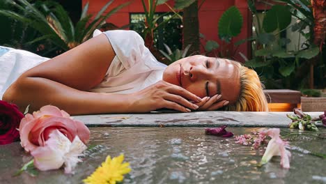 woman resting amongst flowers in a garden