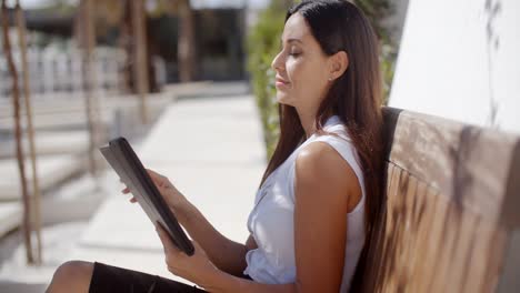 joven mujer de negocios relajándose en un banco al aire libre