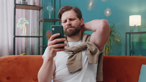 sad young man use smartphone surprised by bad news fortune loss fail lottery results deadline