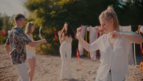 beautiful woman dancing near friends grooving at beach