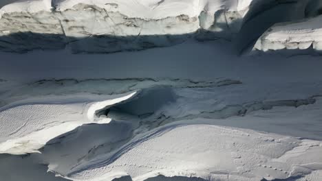 aerial top view of a glacier in the swiss alps, snow-covered surface