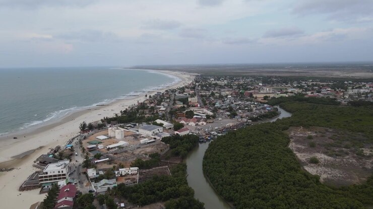 Dronekuva rannikkokaupungista ja rannasta, jossa joki virtaa metsän läpi Morondavassa, Madagaskarilla.