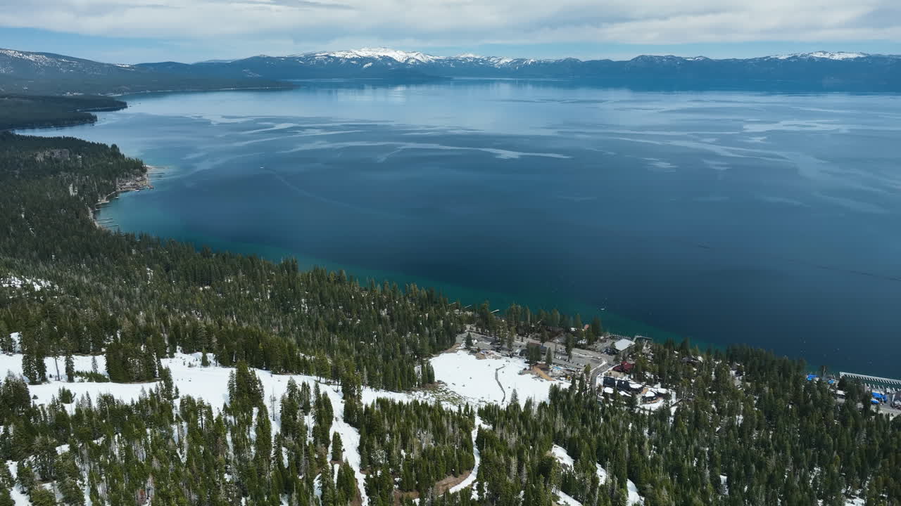 Aerial view over snowy mountains, toward Lake Tahoe, cloudy day in United states
