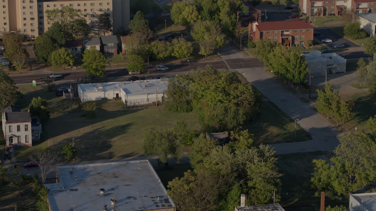 Aerial view of north St. Louis tilt down to storefronts and parked car in parking lot