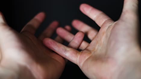 white-caucasian-hand-moving-around-wearing-a-black-wedding-band-with-a-black-background