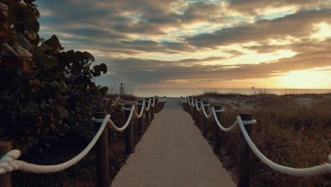 cinematic pov video walking towards the beach on a cloudy and sunny evening in america