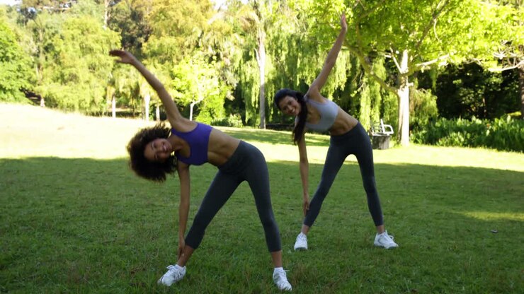 Amigos sorridentes e em forma alongando-se no parque
