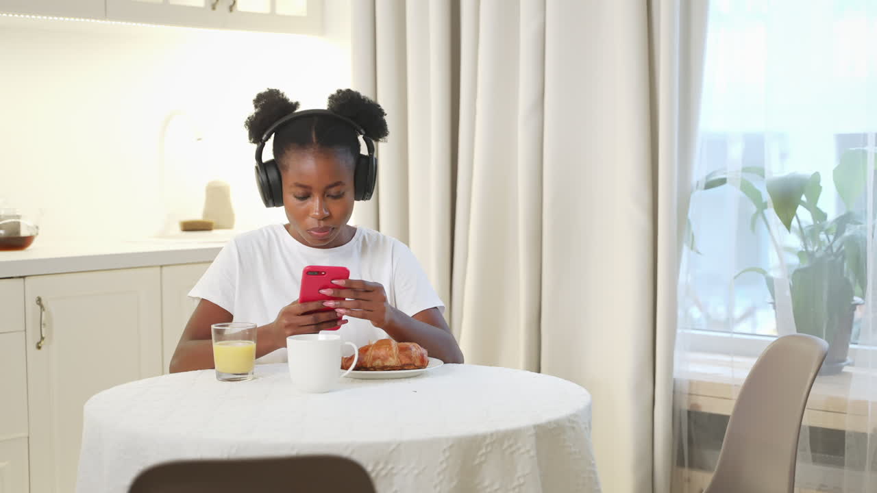 joven tomando el desayuno mientras usa un teléfono