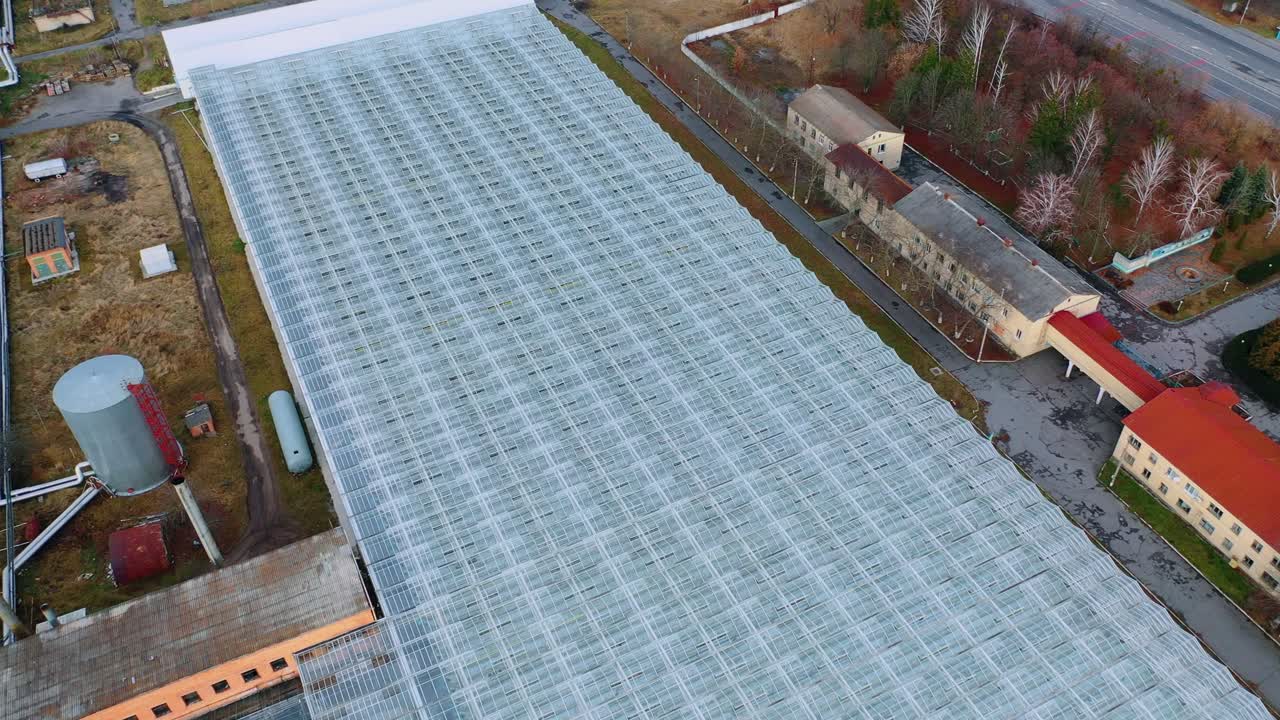 Aerial View Flying Over Large Greenhouse With Vegetables, Greenhouse With Transparent Glass. Technical and administrative buildings
