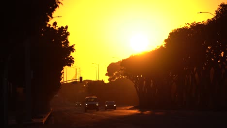 beautiful sunset as cars drive down city street