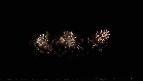 Disparando-Rápidamente-Luces-De-Colores-Brillantes-En-El-Cielo-Frente-A-La-Playa-Para-Un-Festival-Internacional-De-Fuegos-Artificiales