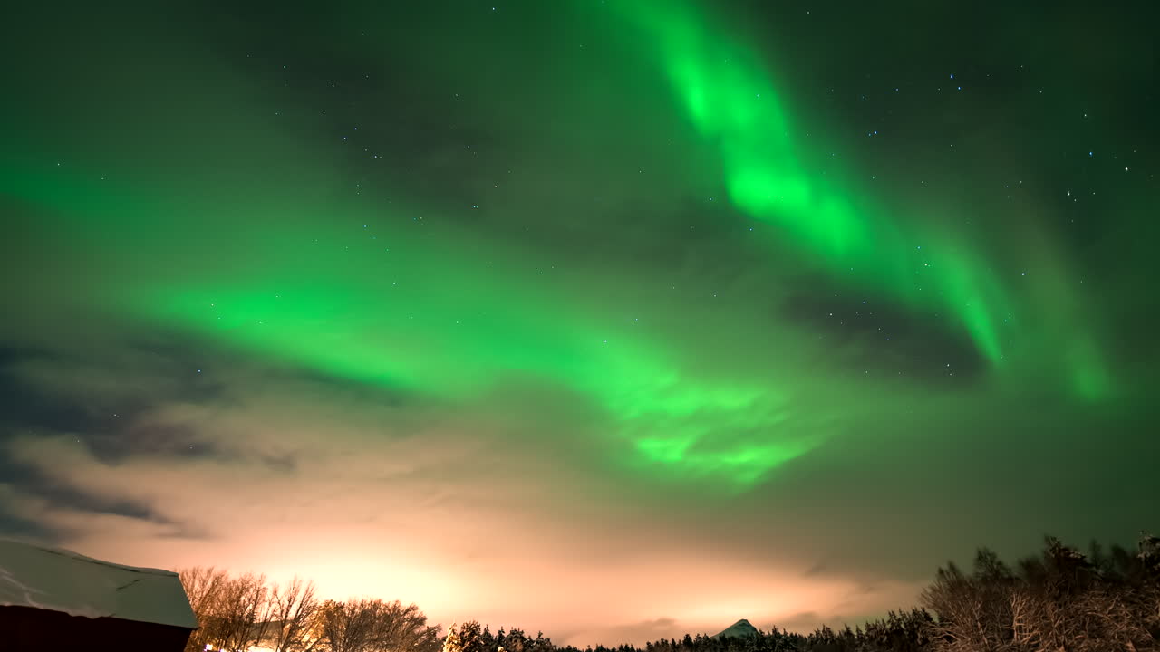 Vivid green aurora borealis swirl across night sky, mesmerizing celestial display. Perfect for nature and astronomy themes. Time-lapse, copy-space
