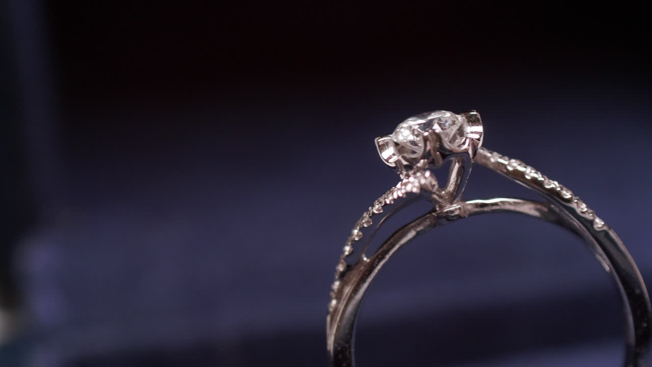 Primo piano di un anello di fidanzamento con diamante, con panoramica dal lato destro a quello sinistro dell'inquadratura.