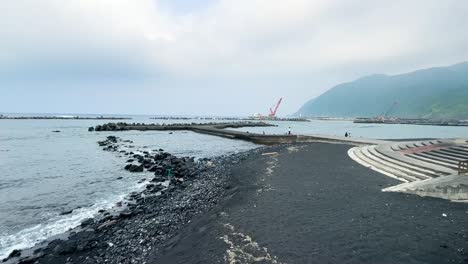 Langsame-Schwenkaufnahme-Der-Überreste-Des-Vulkanischen-Schwarzen-Sandes-Auf-Der-Insel-Hachijo