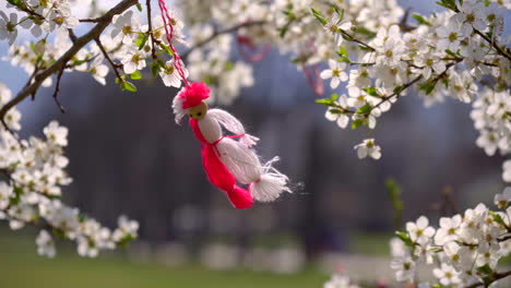 a blossoming tree with white flowers and a martenitsa hanging