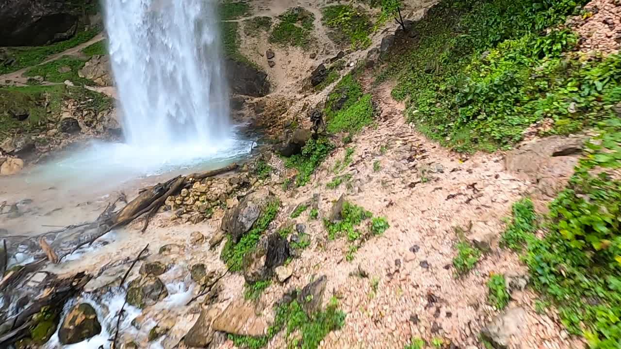 cascada wildenstein en el sur de austria con drones volando detrás de la columna de agua, muñeca aérea en rotación