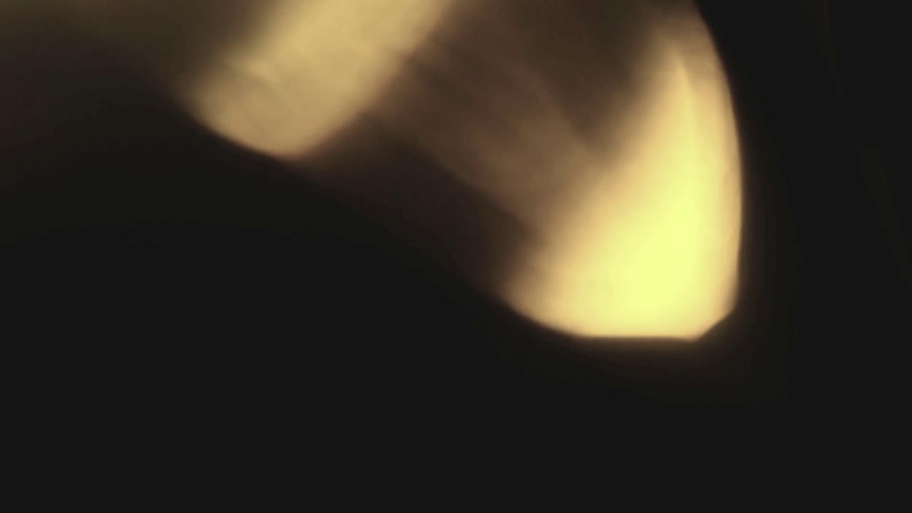 Vazamentos de Luz Dourada em Movimento e Reflexo de Lente em Fundo Escuro