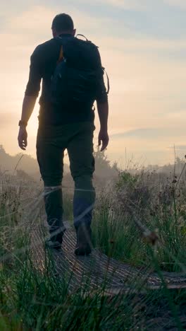 man hiking through misty sunrise