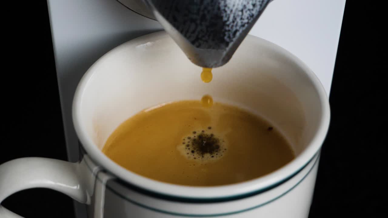 Slow motion shot of coffee drops dropping into a mug
