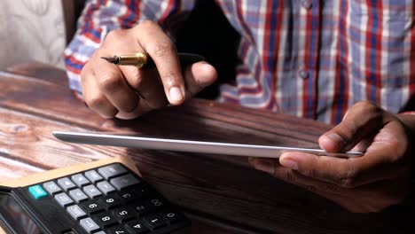 persona que utiliza una tableta y una calculadora