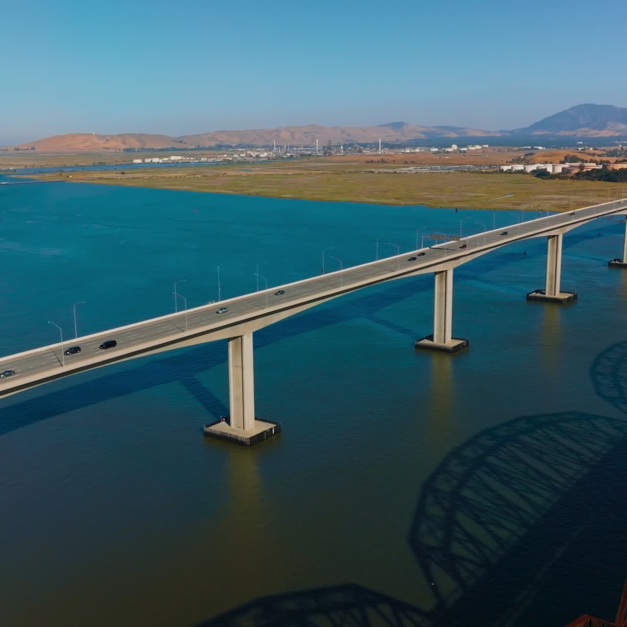 Three neighboring bridges over blue calm water of Carquinez Strait. Martinez-Benicia bridges with lots of cars on. Sunny clear day footage