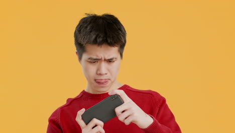 Young man playing a mobile game