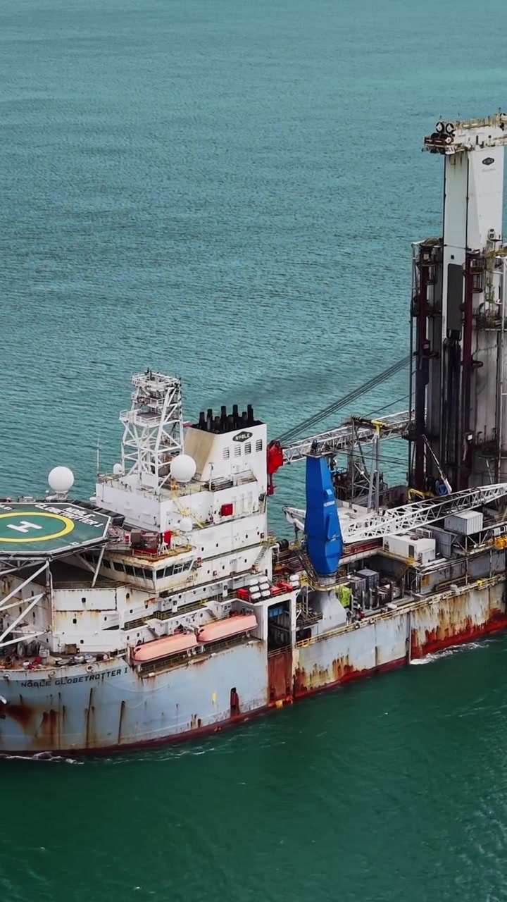 Ship drilling for resources in open water during daylight hours