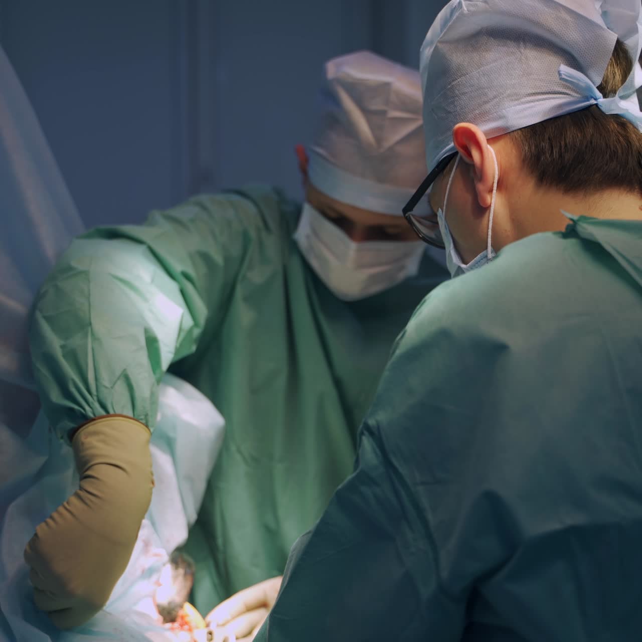 Surgeons collaborating and helping each other at operation. Team of co working doctors aiding one patient