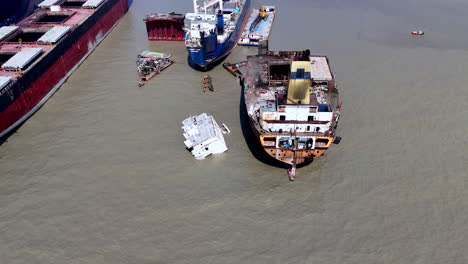 cinematic aerial shot of abandoned wreckage and ships in a ship graveyard in bangladesh