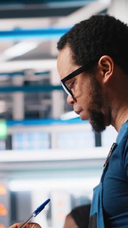 vertical video portrait of engineer in photovoltaics factory reviewing paperwork