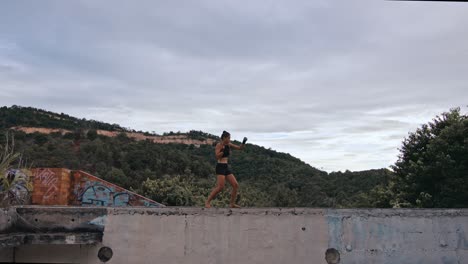 woman practicing kickboxing on a ruined building