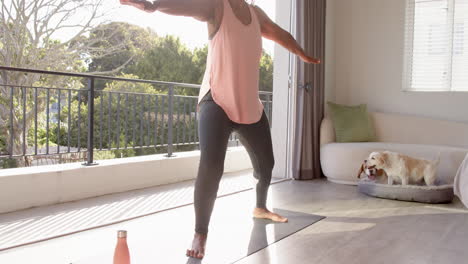 a senior african american woman is practicing yoga at home