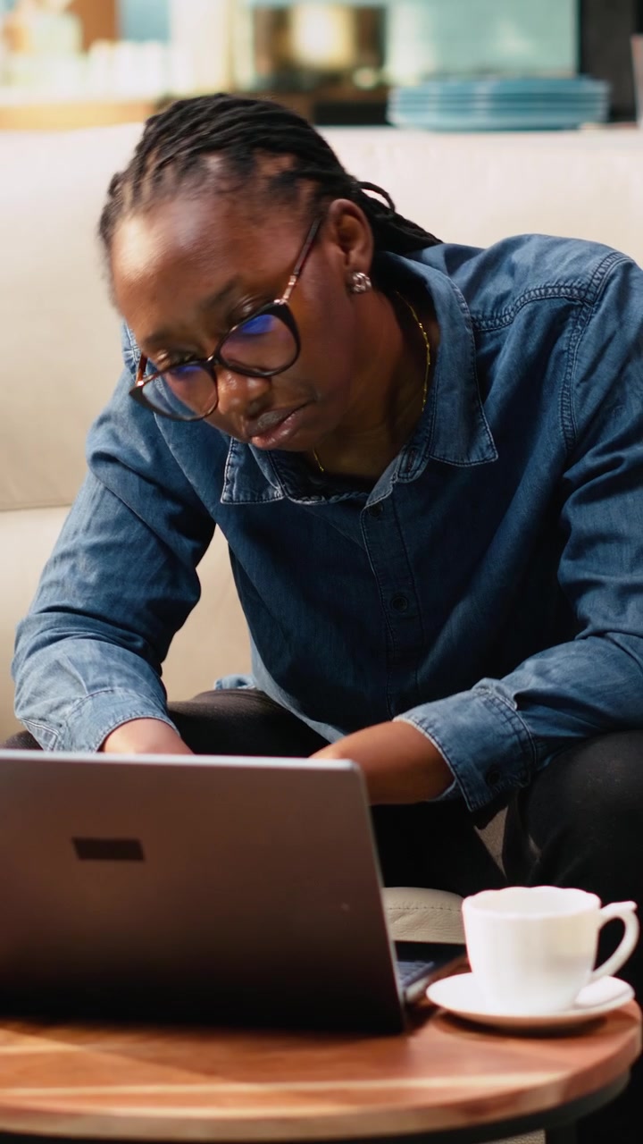 Vertical Video Bored indifferent black girl using laptop with low energy and burnout