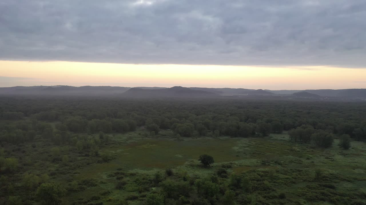 Sunrise over misty forest and mountains