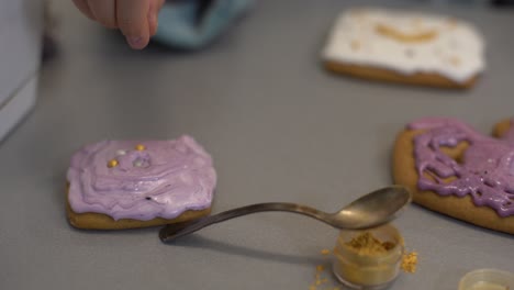 close up view of kids hands decorating homemade cookies for holidays. a child decorates cookies pressing out fondant or paste from a tube