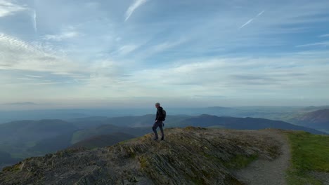 mountain walker on craggy summit at golden hour