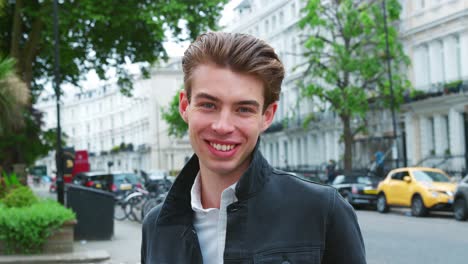 retrato de un joven elegante de pie en la calle de la ciudad