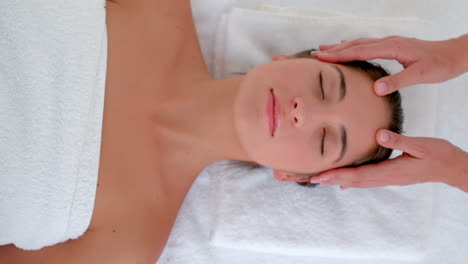 attractive young woman receiving head massage at spa center