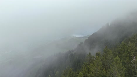 aerial flight through dense clouds between swiss alps in spring