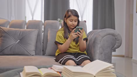 Indian-kid-girl-using-phone-at-home