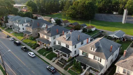 establishing shot of large houses in united states, homes line small town street in america, usa housing residential community neighborhood during summer, aerial drone view