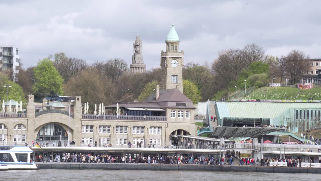 View of St. Pauli's Pier Landungsbrücken station tower with buildings and boats in Hamburg