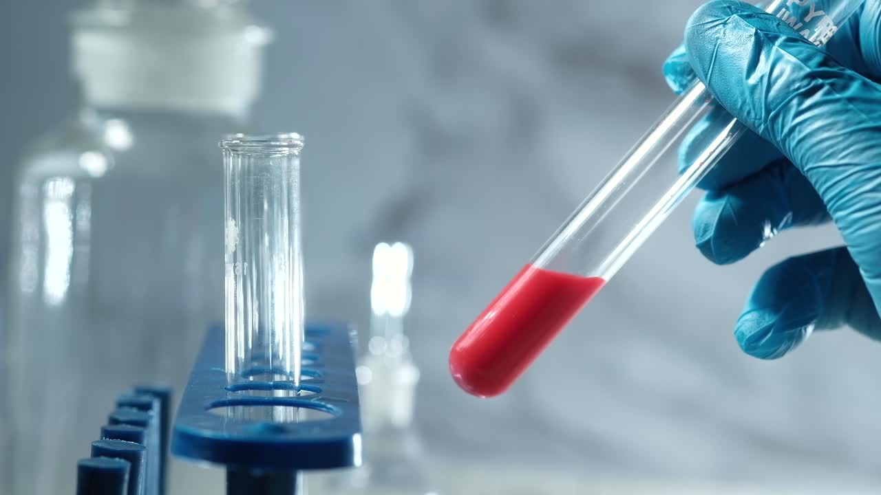 científico realizando un experimento de laboratorio con líquido rojo