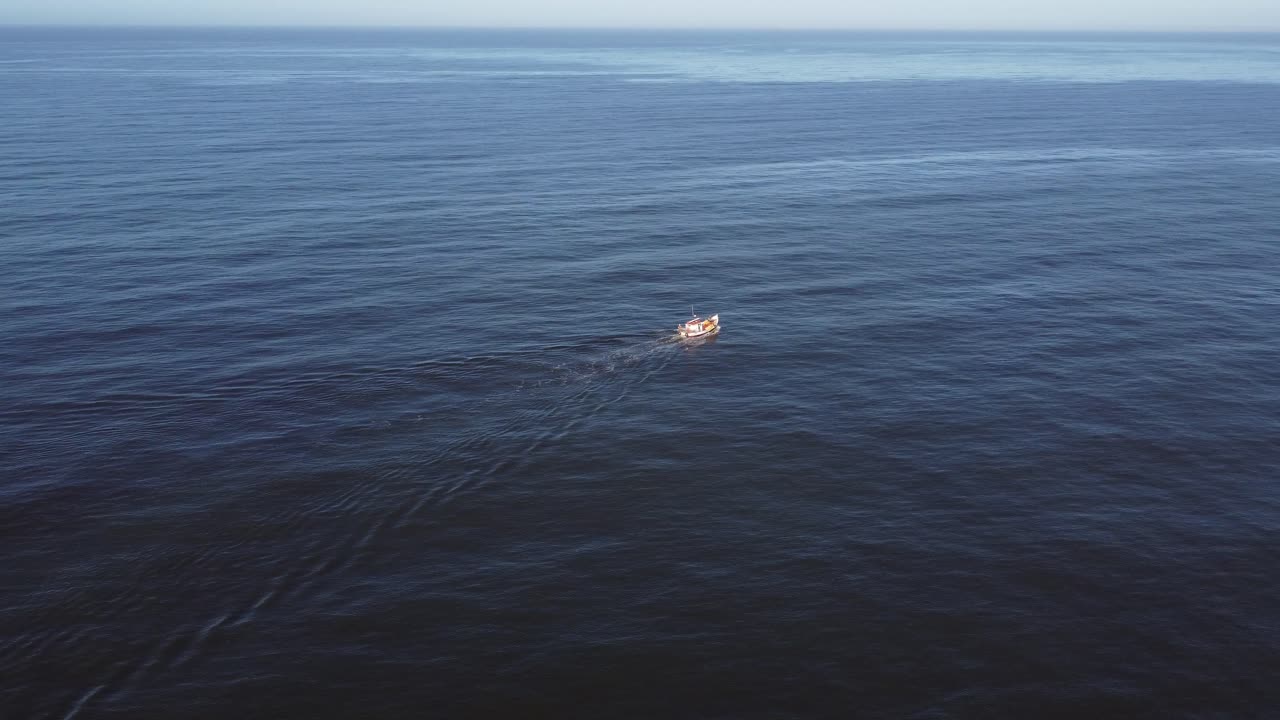 Isolated fishing motorboat navigating on blue sea water