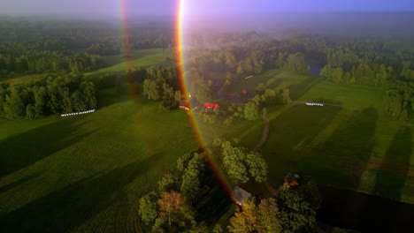 aerial drone view of an amazing double rainbow in a countryside landscape