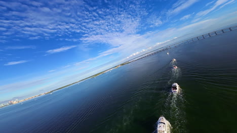 quick flight above the yachts and waterscape sailing by the waterscape. urban skyline of american metropolis at backdrop. fpv drone footage.