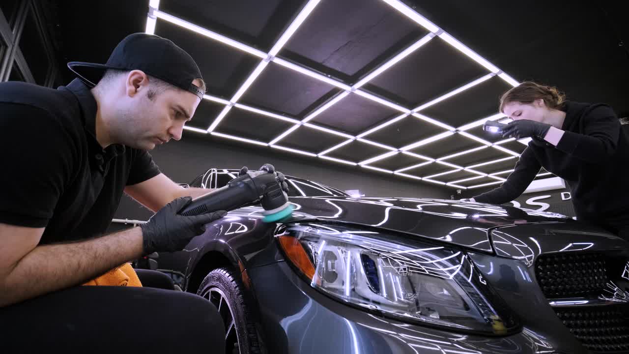 페인트 복원을 위해 기계와 폴리셔를 사용하는 전문 자동차 디테일링.