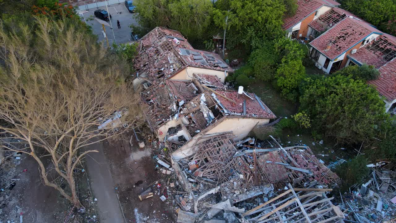 Drone shot in Tel Aviv showing a tree and nearby buildings damaged and collapsed after an Iranian missile strike.