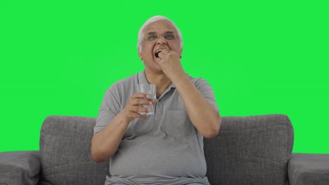 viejo indio feliz tomando medicina pantalla verde